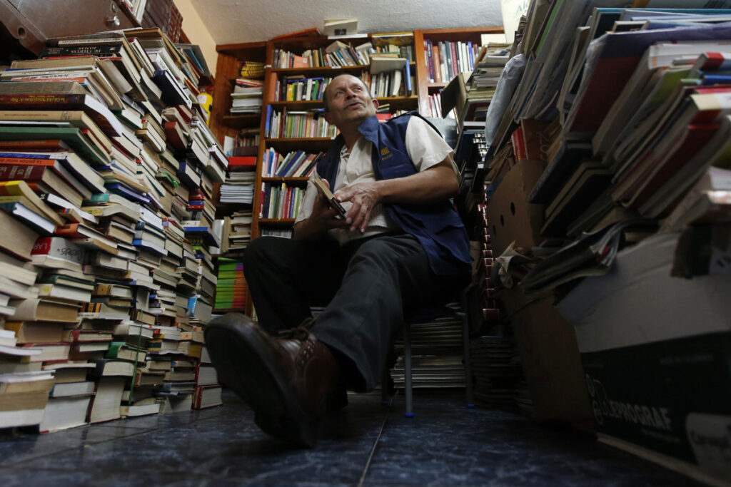 José Alberto Gutiérrez posa en medio de pilas de libros en su casa de Bogotá. Fotografía de archivo.