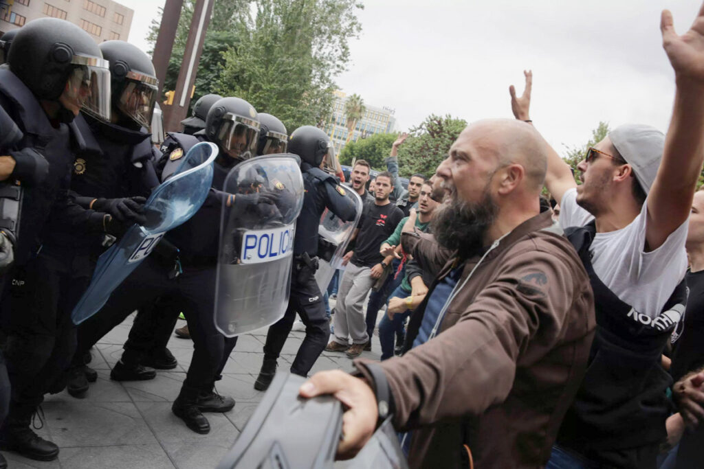 Jóvenes manifestantes frente a la policía antidisturbios española. Fotografía: David González.