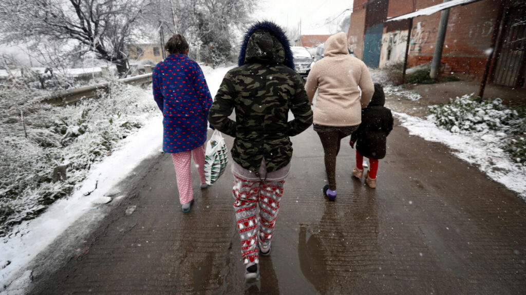 Tres mujeres de la Cañada Real caminan bajo la nieve durante el temporal “Filomena”. Fotografía: Mariscal.
